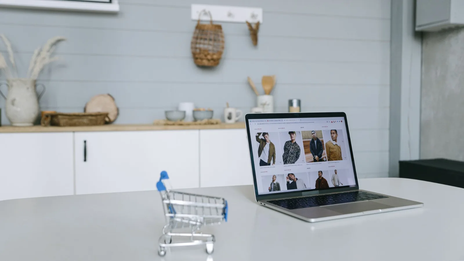 Laptop showing an online store with a shopping cart beside it