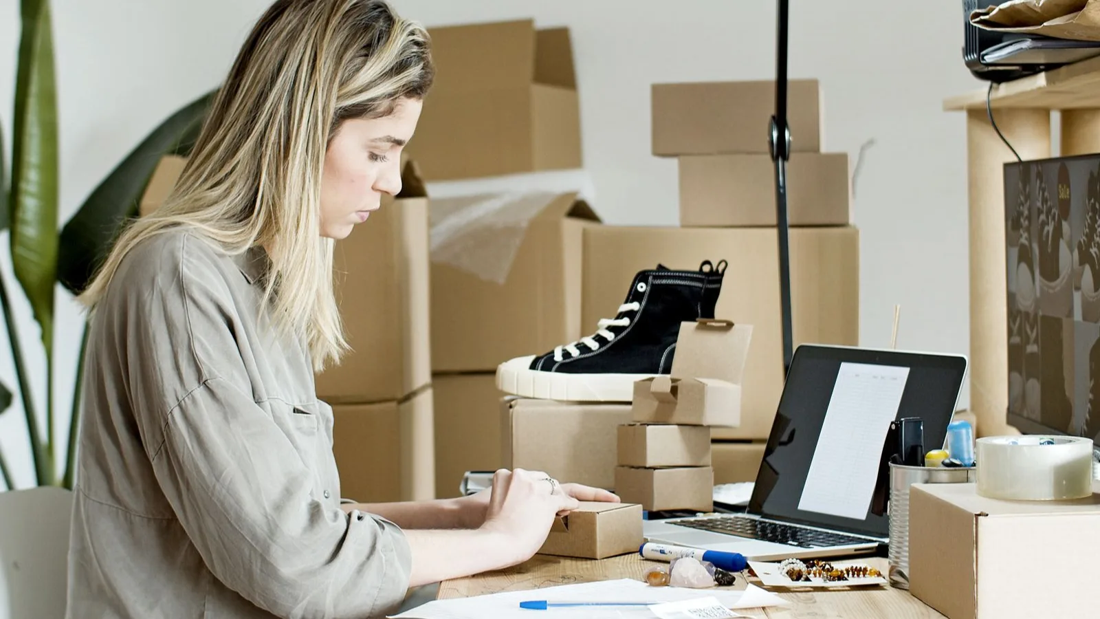 Seller packing orders next to a laptop